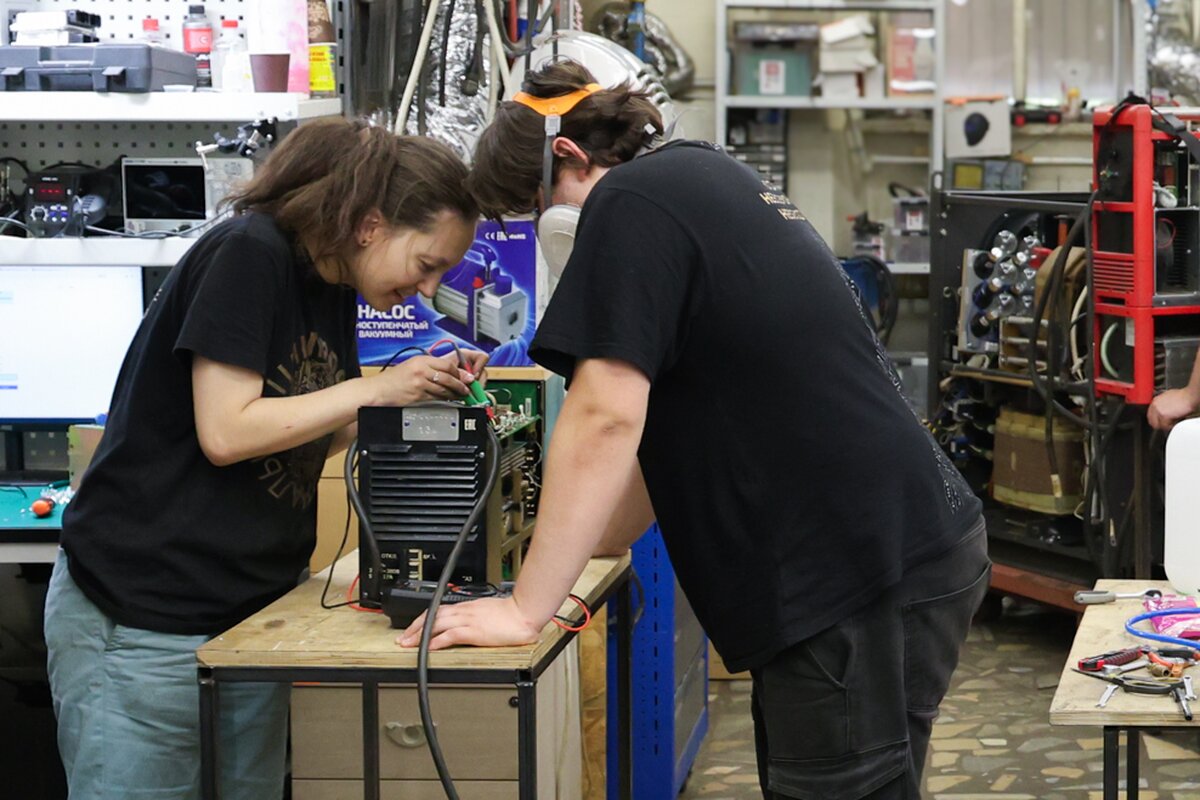 Инженеры ремонтируют сварочный инвертор в мастерской инженерного центра